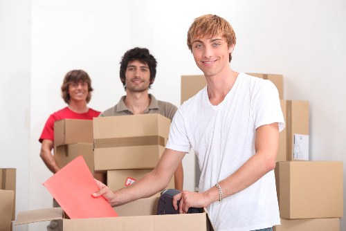 Professional movers handling furniture in a Hampstead flat with narrow access