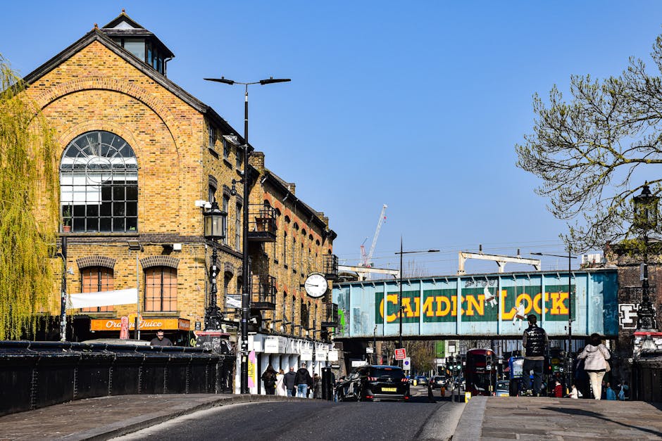 A close-up view of a brick exterior wall displaying a street sign that reads 'LOWER TERRACE NW3' in white letters on a green background, mounted on the red brick surface. The wall is part of a residen